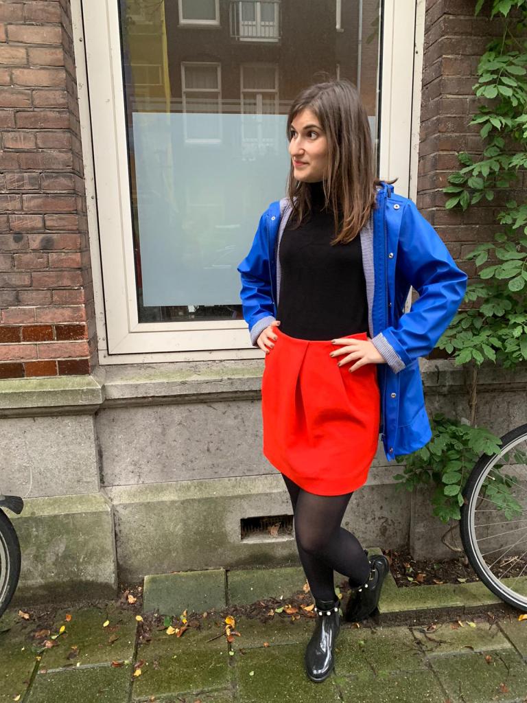 Girl wearing a rain coat, a red mini skirt and rain ankle boots